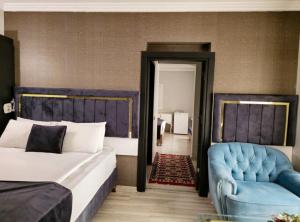 une chambre avec deux lits et une chaise bleue dans l'établissement Yilmazel Hotel, à Gaziantep