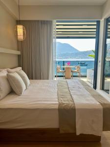 ein Schlafzimmer mit großem Bett und Blick auf das Meer in der Unterkunft Rea Boutique Hotel in Himarë