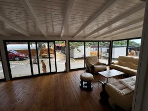 un soggiorno con divano, sedie e finestre di Mobile Home RUŽMARIN a Sveti Juraj