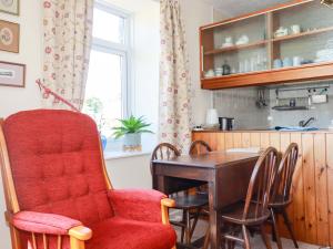 a dining room with a red chair and a table at Chyancrowse in Penzance