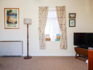 a living room with a window and a television at Chyancrowse in Penzance