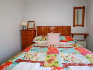 a bedroom with a bed with a quilt on it at Chyancrowse in Penzance