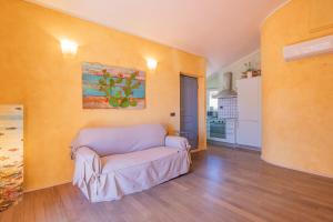 Una sala de estar con un sofá y una cocina. en Il mare in terrazza, en Porto Azzurro