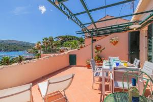Un balcón de una casa con una mesa y sillas. en Il mare in terrazza, en Porto Azzurro
