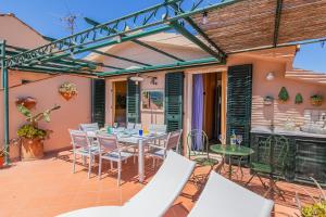Un patio al aire libre con mesa y sillas. en Il mare in terrazza, en Porto Azzurro