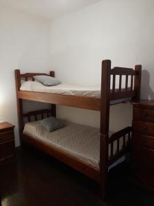 a bedroom with two bunk beds and a dresser at Casa Calma in Colonia del Sacramento