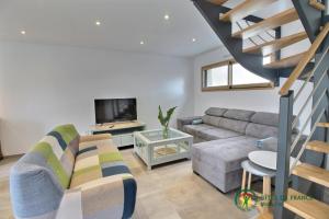 a living room with a couch and a staircase at La grange in Ploeren