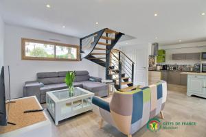 a living room with a staircase and a couch at La grange in Ploeren