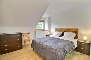 a bedroom with a bed and a dresser and a window at La grange in Ploeren