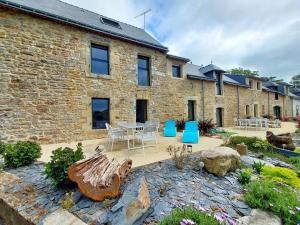 a brick building with a patio with a table and chairs at La grange in Ploeren