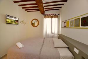 Un dormitorio con una cama grande y una ventana. en Auditorium Rooms, en Foligno