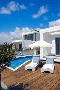 a villa with a swimming pool and two chairs and an umbrella at Luxury Cyprus Villa Aqua Villa Private Pool Sea View 2 Bdr Paphos in Paphos +3 photos