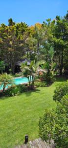 a green yard with a swimming pool and trees at Complejo Aramis Chapadmalal in Chapadmalal