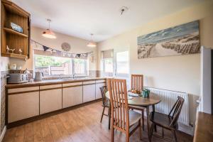 a kitchen with a table and chairs and a dining room at Everglades, Reydon in Reydon