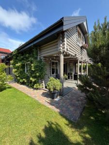 a house with a porch and a grass yard at Rasos Vila in Palanga