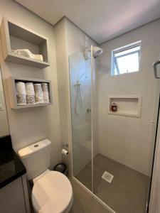 um banheiro com vaso sanitário e box de vidro em Loft próximo a Vila Germânica 310 em Blumenau