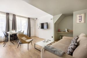 a living room with a couch and a table at Au Chat Qui Dort Lille - Archives 3 in Lille