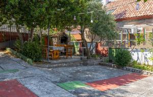 a garden with a table and trees and a building at 4 Bedroom Awesome Apartment In Sveti Juraj in Sveti Juraj