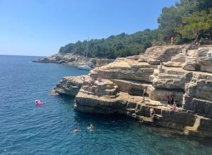 a group of people swimming in a body of water at Modern Villa with Garden & Terrace, 13 min to Pula Arena in Pula