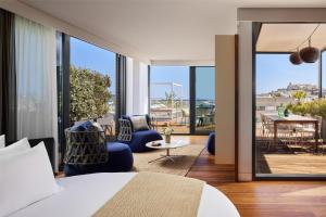 - une chambre avec un lit et une vue sur une terrasse dans l'établissement NH Collection Ibiza, à Ibiza