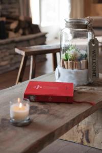 a candle and a red book on a table with a jar at Appartement Flocon de Nell in Megève