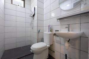a white bathroom with a toilet and a sink at Serene Japandi Family Retreat 2-6 pax& Sunrise View in Brinchang +23 photos