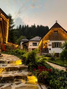 a house and a garden with flowers in front of it at Locul cu Amintiri in Albac