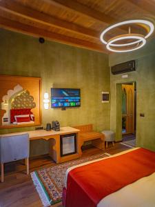 a bedroom with a bed and a desk and a tv at Fabrizio del Carretto in Rhodes Town