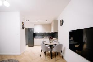 a kitchen and dining room with a table and chairs at Obywatelska Lotnisko Airport Parking Balkon z widokiem Klima in Łódź