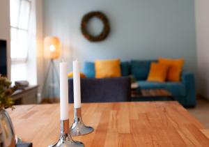 two white candles on a table in a living room at Ferienwohnung Smilla in Tecklenburg +17 photos