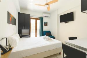 a bedroom with a bed with a ceiling fan at Alcentro Studio 2 in Platamonas