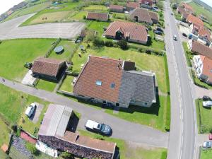 una vista aérea de una casa con una carretera y un patio en vakantiehuis op terschelling, en Baaiduinen