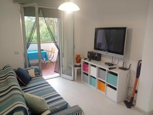 a living room with a couch and a television at Baia 55 in Lido di Spina
