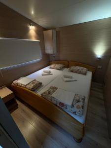 due letti singoli in una piccola stanza con una lavagna bianca di Mobile Home RUŽMARIN a Sveti Juraj