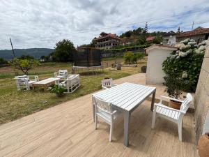 a white table and chairs on a wooden deck at Casa Conde in Pontevedra