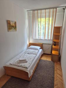 ein kleines Schlafzimmer mit einem Bett und einem Fenster in der Unterkunft Apartman Pasarela - mirna lokacija u centru in Bihać