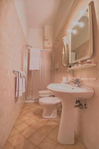 a bathroom with a sink and a toilet and a mirror at Hotel Bristol in Lavagna