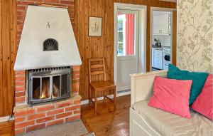 a living room with a brick fireplace and a couch at 2 Bedroom Stunning Home In Klintehamn in Klintehamn