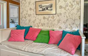 a couch with colorful pillows on it in a room at 2 Bedroom Stunning Home In Klintehamn in Klintehamn