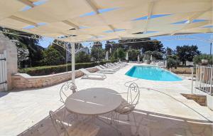 a patio with a table and chairs and a pool at Masseria Carperi in Cisternino