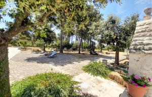 un parque con un banco, árboles y flores en Amazing Home In Cisternino, en Cisternino