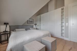 a bedroom with a large bed and two stools at Haus Strandhafer in List