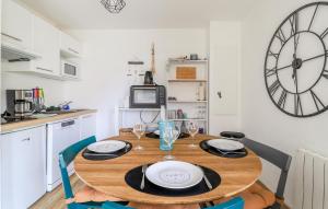 a dining room table with chairs and a clock on the wall at Jolie Maison Avec Terrasse in Le Crotoy