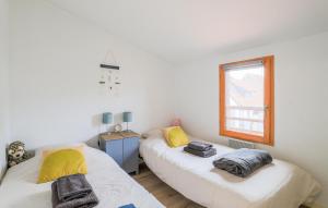 two beds in a room with a window at Jolie Maison Avec Terrasse in Le Crotoy +19 photos