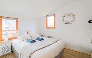 a bedroom with a bed with white sheets and a window at Jolie Maison Avec Terrasse in Le Crotoy