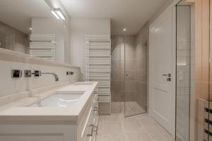 a white bathroom with a sink and a shower at Haus Strandhafer in List +29 photos