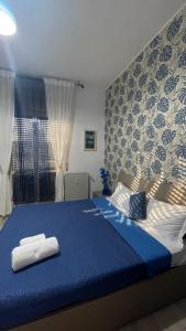 a bedroom with a blue bed with towels on it at Casa Amore a Bergamo in Bergamo