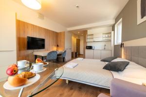 a bedroom with a bed and a table with food on it at Wolska Residence I in Warsaw
