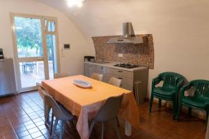 a kitchen with a table and chairs and a kitchen with a stove at Villa dei Mandorli in Naro