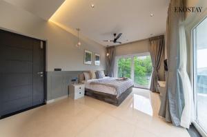 a bedroom with a bed and a large window at EKOSTAY - Amber Villa in Kodaikānāl